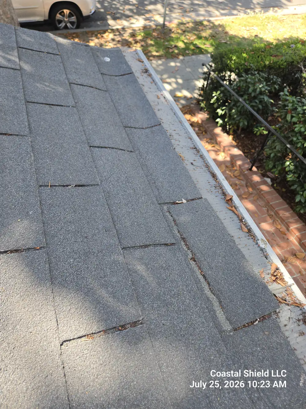 Gutter with mesh guard beginning to collect debris at the eave, found during an annual maintenance inspection