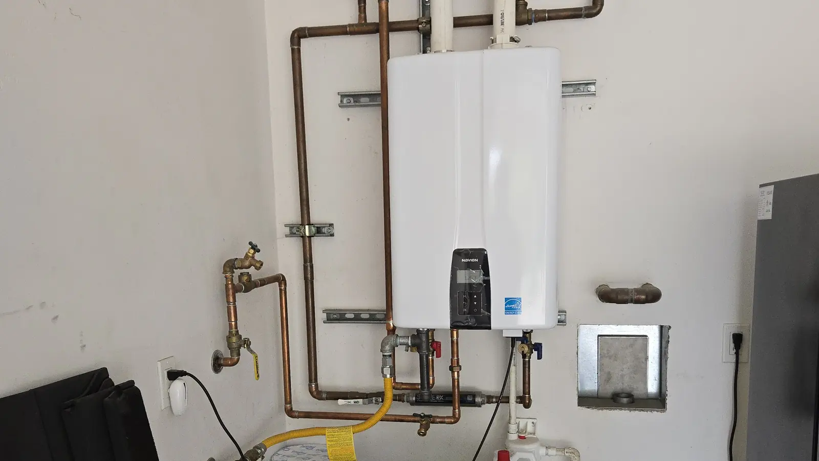 Tankless water heater and copper supply manifold documented during a Santa Barbara plumbing inspection