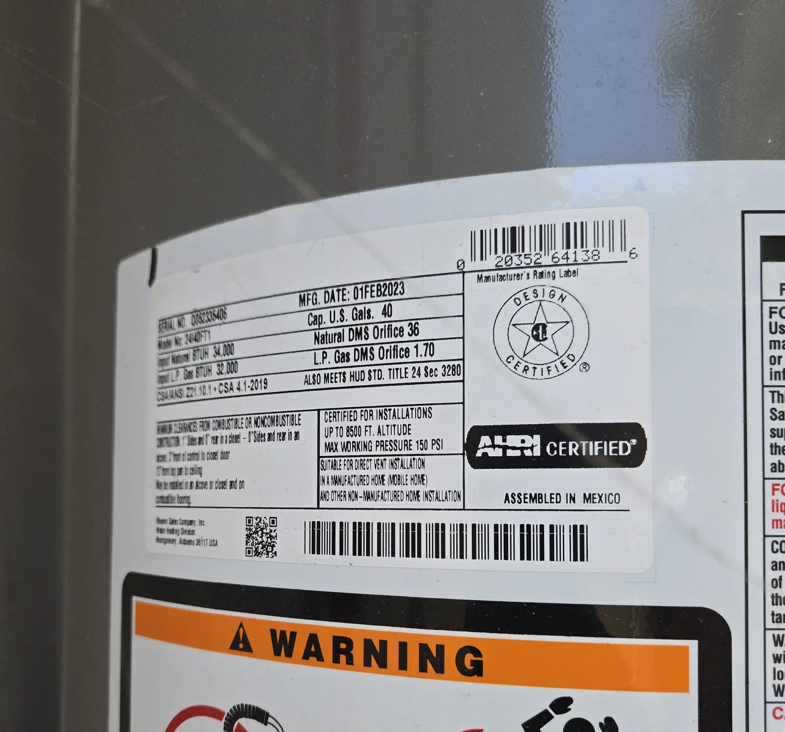 Water heater manufacturer data plate photographed in the field — serial, capacity, and manufacture date recorded